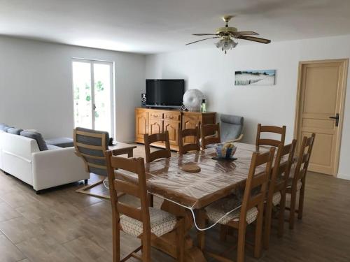 - une salle à manger avec une table et des chaises en bois dans l'établissement Villa dans la pinède, au calme à proximité du lac et des plages, jusqu'à 7 personnes, à Biscarrosse