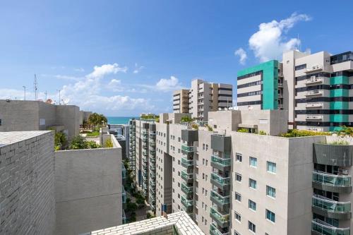 una ciudad con edificios altos y el océano en JTR - Apartamento Beira Mar em Maceio, en Maceió