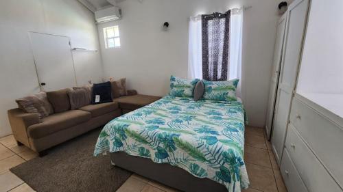 a bedroom with a bed and a couch at Caribbean Dream Vacation Property CD3 in Rodney Bay Village
