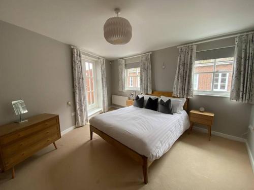 a bedroom with a bed and two windows at The Penthouse, Winchester in Winchester