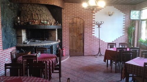 a restaurant with tables and chairs and a fireplace at Семеен хотел НАЦИОНАЛ in Mineralni Bani