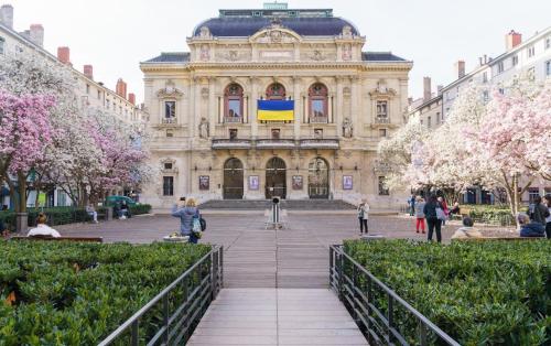 a large building with people walking in front of it at Hotel du Théatre in Lyon