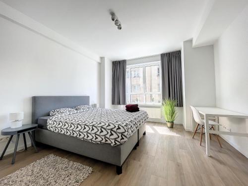 ブリュッセルにあるCosy Apartment Brussels - Avenue Louiseのベッドルーム1室(ベッド1台、デスク、窓付)