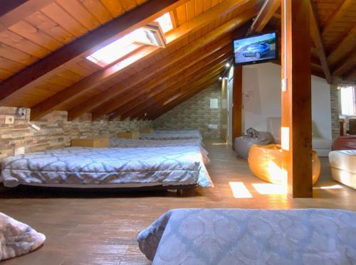 a attic room with two beds and a tv at Na Crista da Onda in Nazaré