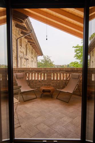 a patio with two chairs and a bench on a balcony at Casale San Pietro in Palmanova