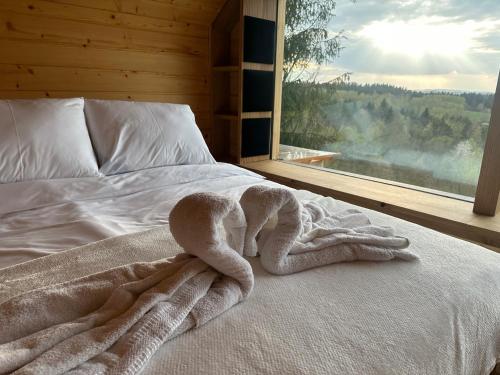 a bed with a towel on it next to a window at Bieszczadzki Zagajnik in Lesko