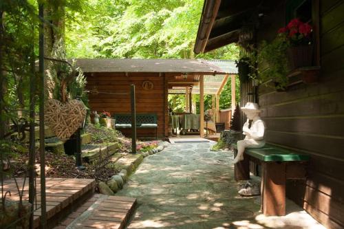 a statue of a woman sitting on a bench in a garden at Penthouse-Suite Mountain View mit Waldhütte/Sauna/Netflix in Nachdemsee