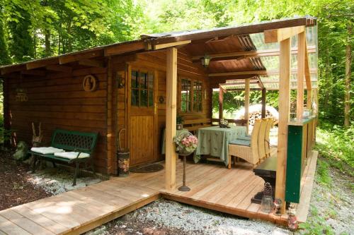 a small wooden cabin with a table on a deck at Penthouse-Suite Mountain View mit Waldhütte/Sauna/Netflix in Nachdemsee