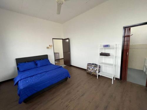 Kampung Kerangi的住宿－Villa President Homestay -4 bedroom Aircond WIFI Vacations Home，一间卧室配有一张带蓝色棉被的床