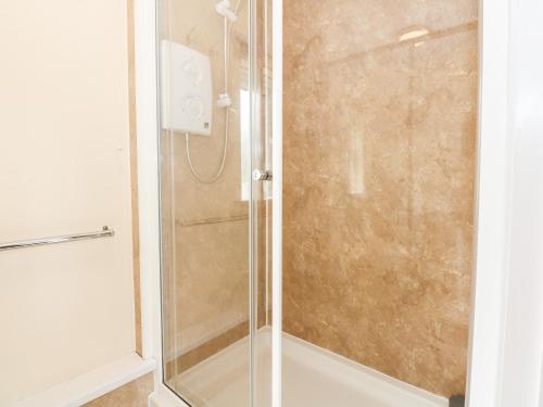 a shower with a glass door in a bathroom at 12 The Dell in Norwich
