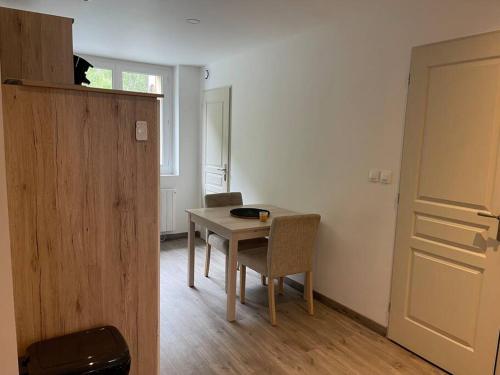 a room with a table and chairs and a door at appartement 46m2 au coeur du parc de la Vanoise in Fourneaux