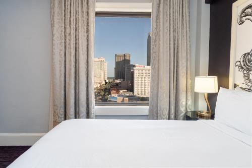 Un dormitorio con una gran cama blanca y una ventana en Hampton Inn & Suites New Orleans Canal St. French Quarter, en Nueva Orleans