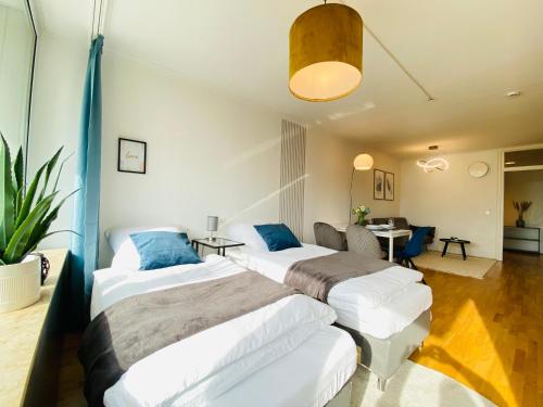 Habitación de hotel con 2 camas y mesa en KYANIT APARTMENT: FREE PARKING + POOL + NETFLIX, en Wuppertal