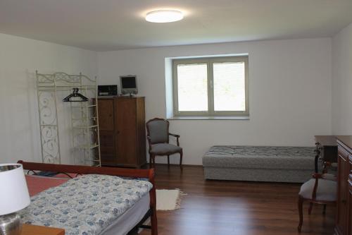 1 dormitorio con cama y ventana en Das Blaue Haus Guesthouse - Kovácshida en Kovácshida