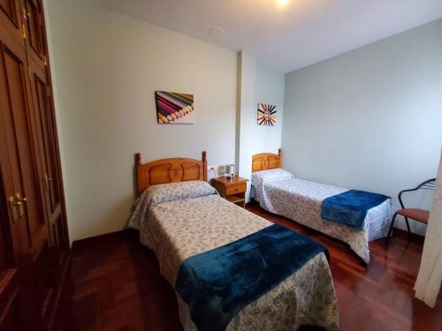 een hotelkamer met 2 bedden en een stoel bij Magnifico apartamento en O Grove in O Grove