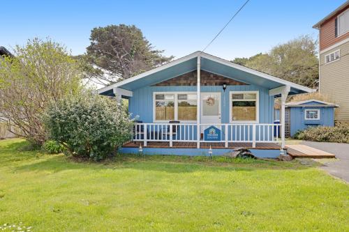 a blue house with a porch and a yard at Beach Haven in Lincoln City