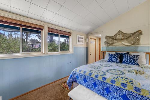 a bedroom with a bed and two windows at Beach Haven in Lincoln City