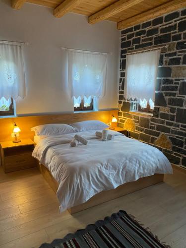 a bedroom with a large bed with two towels on it at Hotel Kaso Ervehe in Përmet