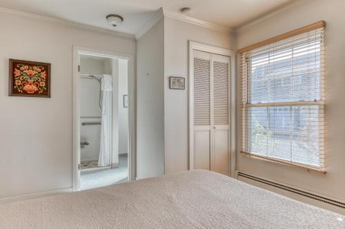 a bedroom with a bed and a window and a mirror at Seaside Governor's House Vacation Rental in Seaside