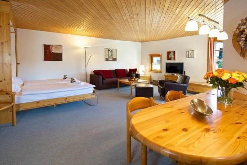 uma sala de estar com uma cama e uma mesa em Apartment Schweizerhof 242 Lenzerheide em Lenzerheide