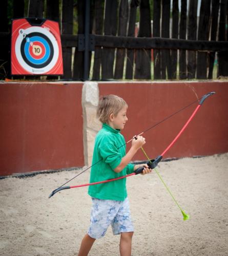 a young boy holding a kite in front of a target at Apartmány u Dlouhána in Kadaň