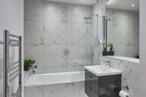e bagno con doccia, lavandino e vasca. di Kings Oak House by Viridian Apartments a Londra