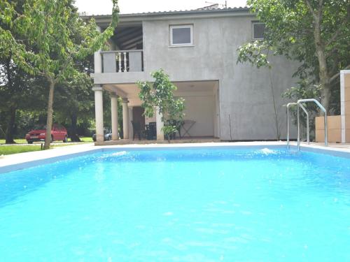 a large blue swimming pool in front of a house at Apartment in holiday home with private pool garden with grill airco and wifi in Banjole
