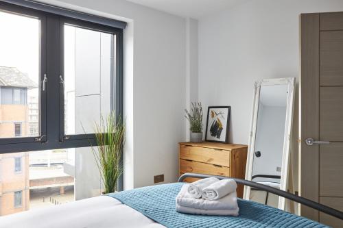 a bedroom with a bed and a large window at Kings Oak House by Viridian Apartments in London