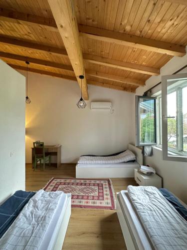 una camera con 2 letti e un soffitto in legno di Bora a Pejë