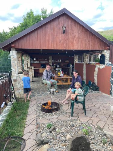a family sitting around a fire pit in a backyard at Apartmány u Dlouhána in Kadaň