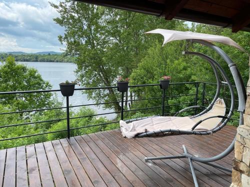 a chair on a deck with a view of a lake at Apartmány u Dlouhána in Kadaň