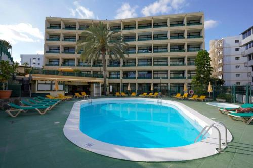 um hotel com piscina em frente a um edifício em Stylish apartment with stunning sea view. em Maspalomas