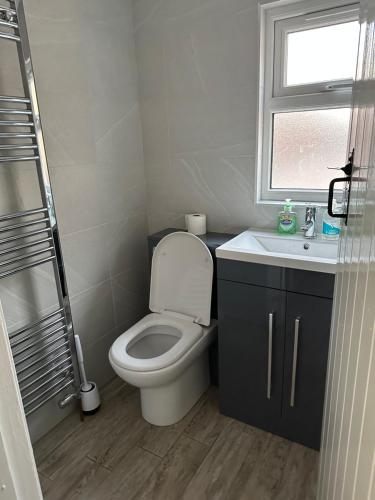 a bathroom with a toilet and a sink and a window at 14 crouch road in Burnham on Crouch