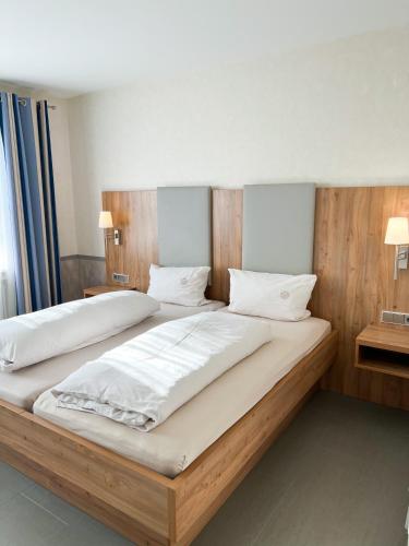 a bedroom with two beds with white sheets and pillows at Hotel Garni Illertal in Altenstadt