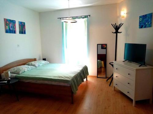 a bedroom with a bed and a dresser with a television at Lovely Studio in Old Town in Labin