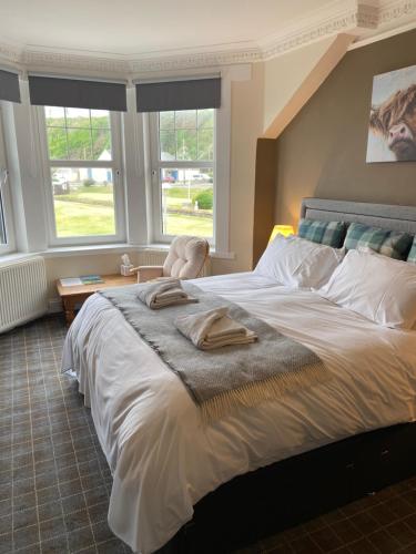 a bedroom with a large bed with two towels on it at No 4 Portpatrick B&B in Portpatrick