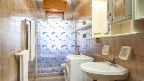 ein Badezimmer mit einem Waschbecken und einem Duschvorhang mit Delfinen in der Unterkunft Villetta Ischia by Salento Affitti in Marina di Mancaversa