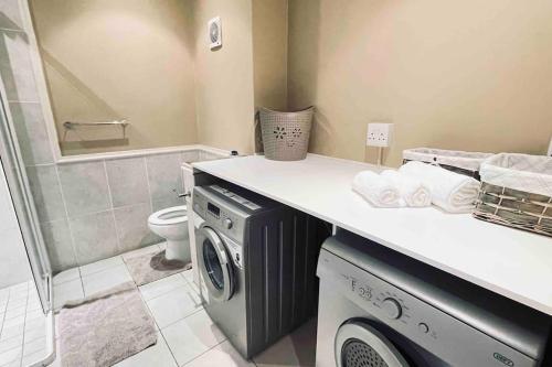a bathroom with a washing machine and a toilet at Lifestyle Villa at Pinnacle in Mossel Bay
