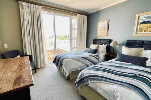 a bedroom with two beds and a large window at Lifestyle Villa at Pinnacle in Mossel Bay