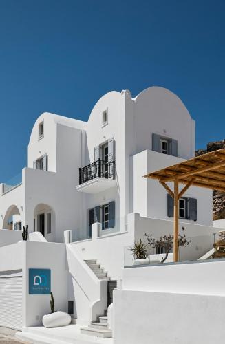 a white building with white stairs in front of it at Bluewhite Suites & Villa Santorini in Pirgos