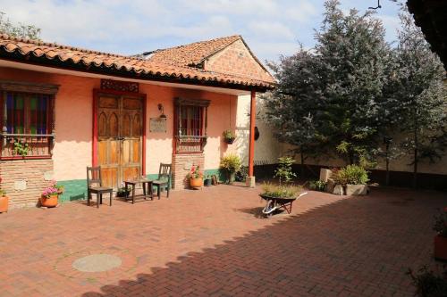 um pátio de uma casa com uma mesa e cadeiras em la posada del angel em Zipaquirá