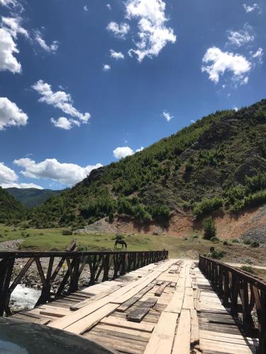 a bridge over a river with a horse on it at Bujtina Gjana in Kukës