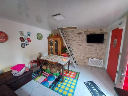 a small living room with a table and a tv at Au Ch'ti Marnais. Gîte au cœur des vignes. in Nesle-le-Repons