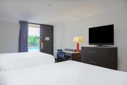 a hotel room with two beds and a flat screen tv at My Homes Macon North I-75 By OYO in Macon