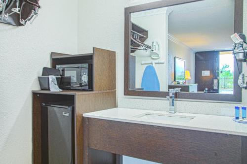 a bathroom with a sink and a mirror at My Homes Macon North I-75 By OYO in Macon