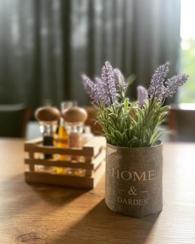 a vase with purple flowers sitting on a table at GRAND JNK Boutique Hotel in Kukës