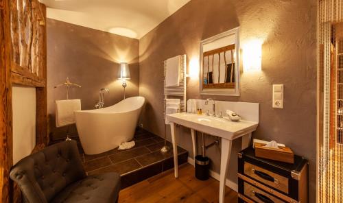 ein Badezimmer mit einer Badewanne und einem Waschbecken in der Unterkunft Das Bucher in Ehrwald