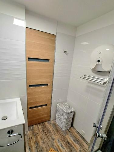 La salle de bains est pourvue d'un lavabo et d'une porte en bois. dans l'établissement Appartement avec parking Cap d'Agde, La Falaise, au Cap d'Agde
