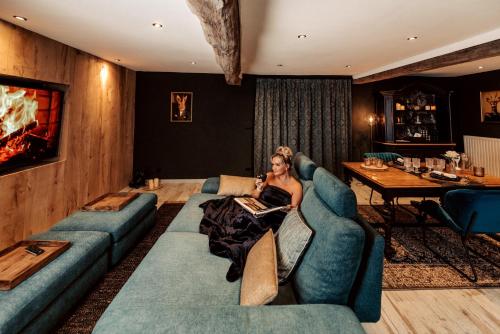 a woman sitting on a couch in a living room at Pause Cachée in Walhain-Saint-Paul
