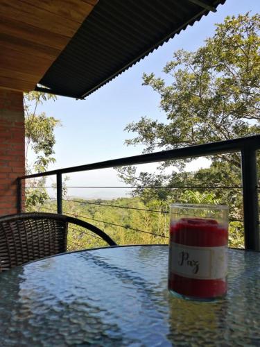 a glass on a table with a view of a field at Pistacho in Minca